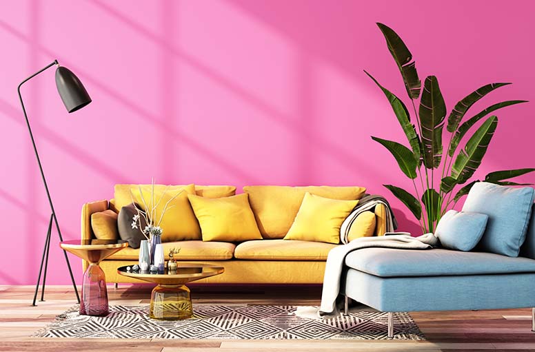 Pinkki seinä ja keltainen sohva